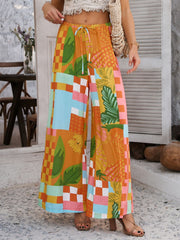Geometric print wide-leg trousers with drawstring waist in multicolor patchwork pattern.