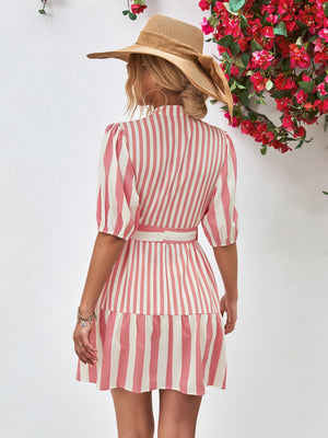 Blush pink and white vertical stripe shirred waist dress with puff sleeves and tiered skirt.