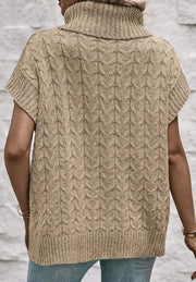 Khaki cable knit turtleneck capelet sweater with short sleeves and ribbed trim.