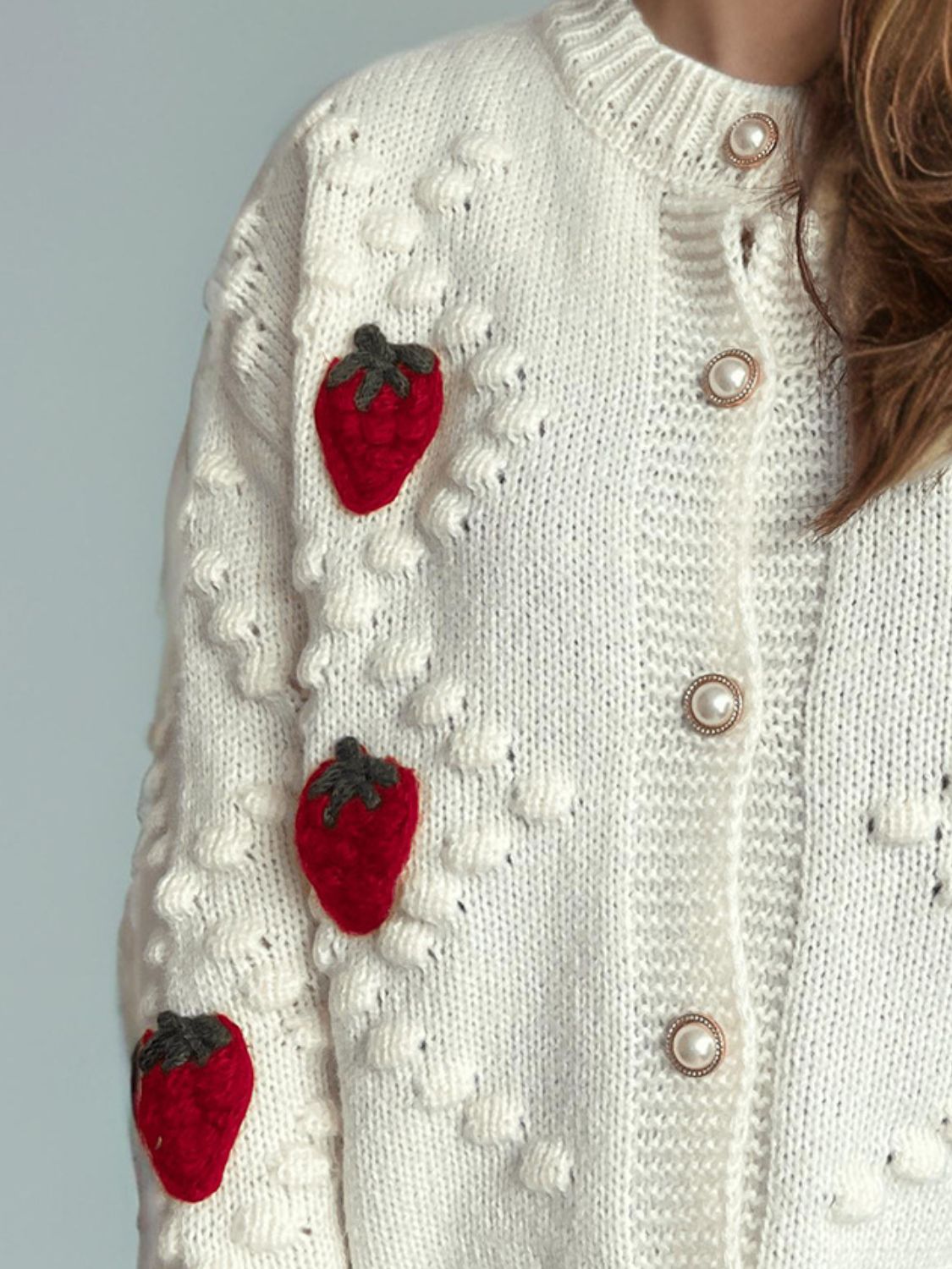 White knit cardigan with strawberry patches and pearl buttons