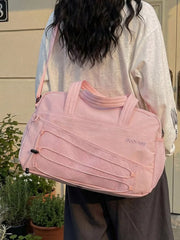 Pink nylon travel organizer bag with bungee cord detail and adjustable strap.