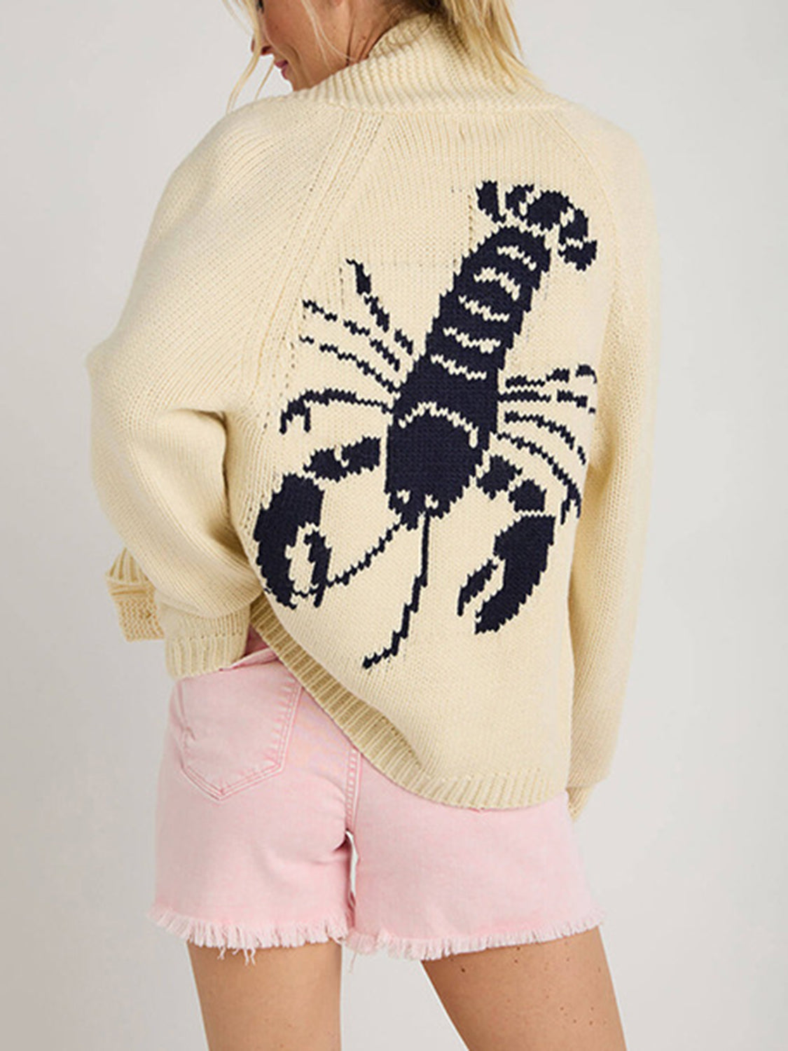 Cream knit cardigan with navy lobster appliqué on back, long sleeves, ribbed trim.