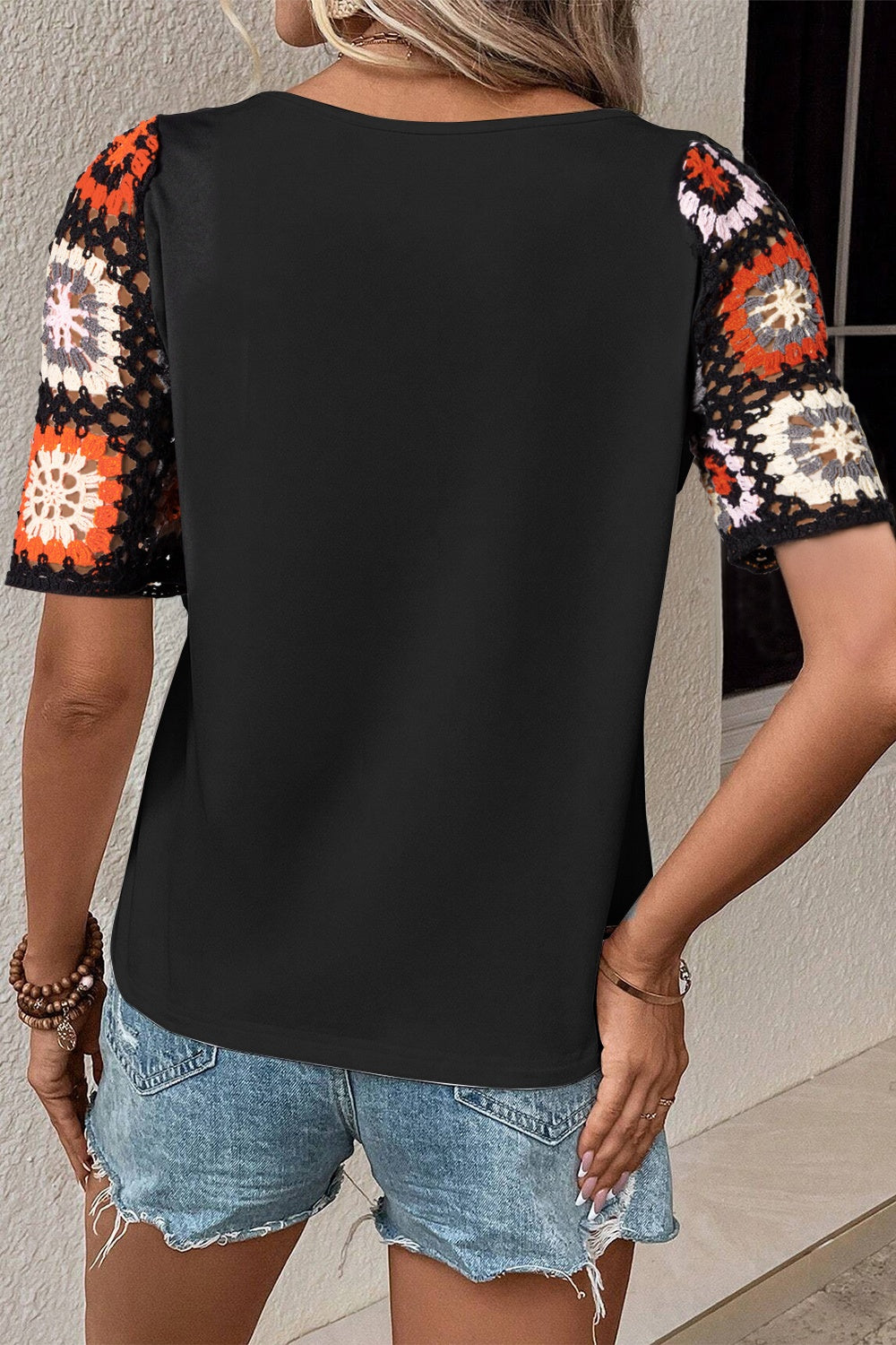 Black tee with colorful granny square crochet sleeves and a crew neck.
