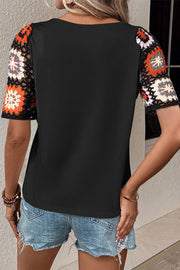 Black tee with colorful granny square crochet sleeves and a crew neck.
