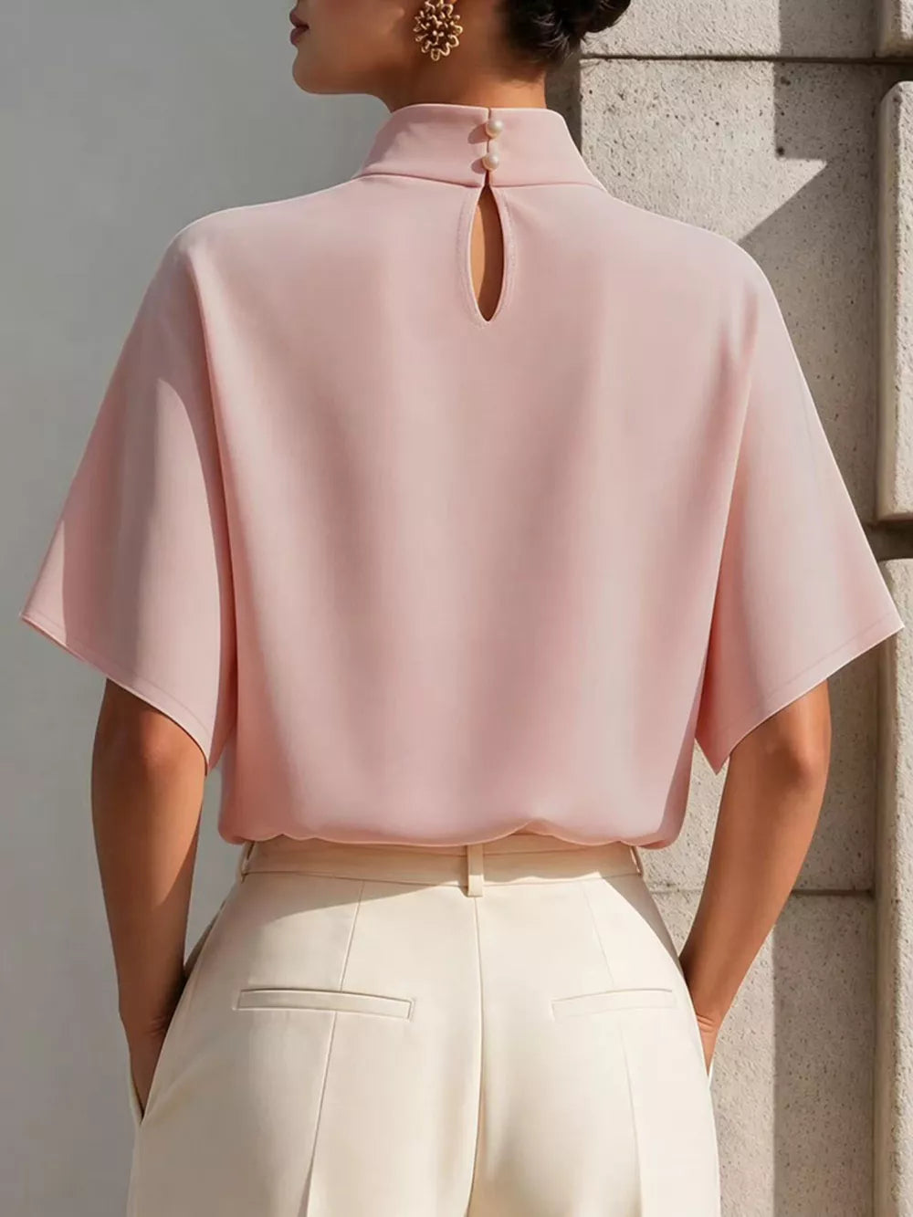 Blush pink polyester mock neck t-shirt with relaxed sleeves and back keyhole detail.
