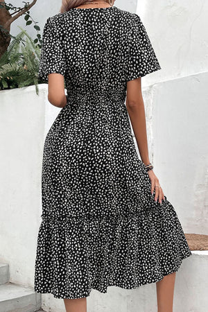 Black floral print midi dress with smocked waist and flutter sleeves.
