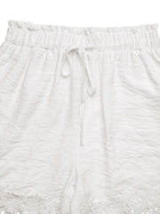 White drawstring waist shorts with lace trim and textured fabric.