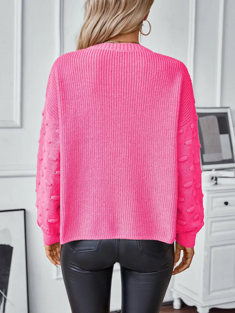Hot pink knit sweater with textured sleeves and ribbed detail, crew neck, long sleeves.