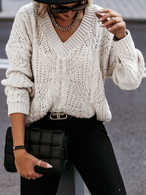 Ivory cable knit v-neck relaxed sweater with textured stitching and balloon sleeves.