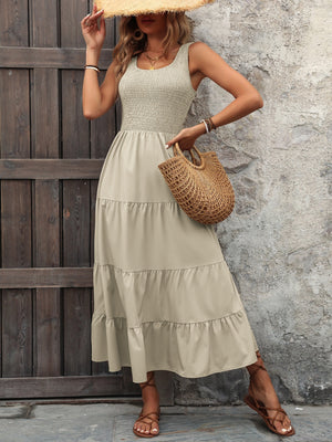 Beige smocked bodice tiered maxi dress with square neckline and sleeveless cut.