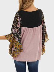 Blouse with black waffle knit, pink waffle knit body, and floral print flutter sleeves.