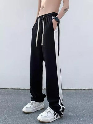 Black sweatpants with white side stripes and drawstring waist.