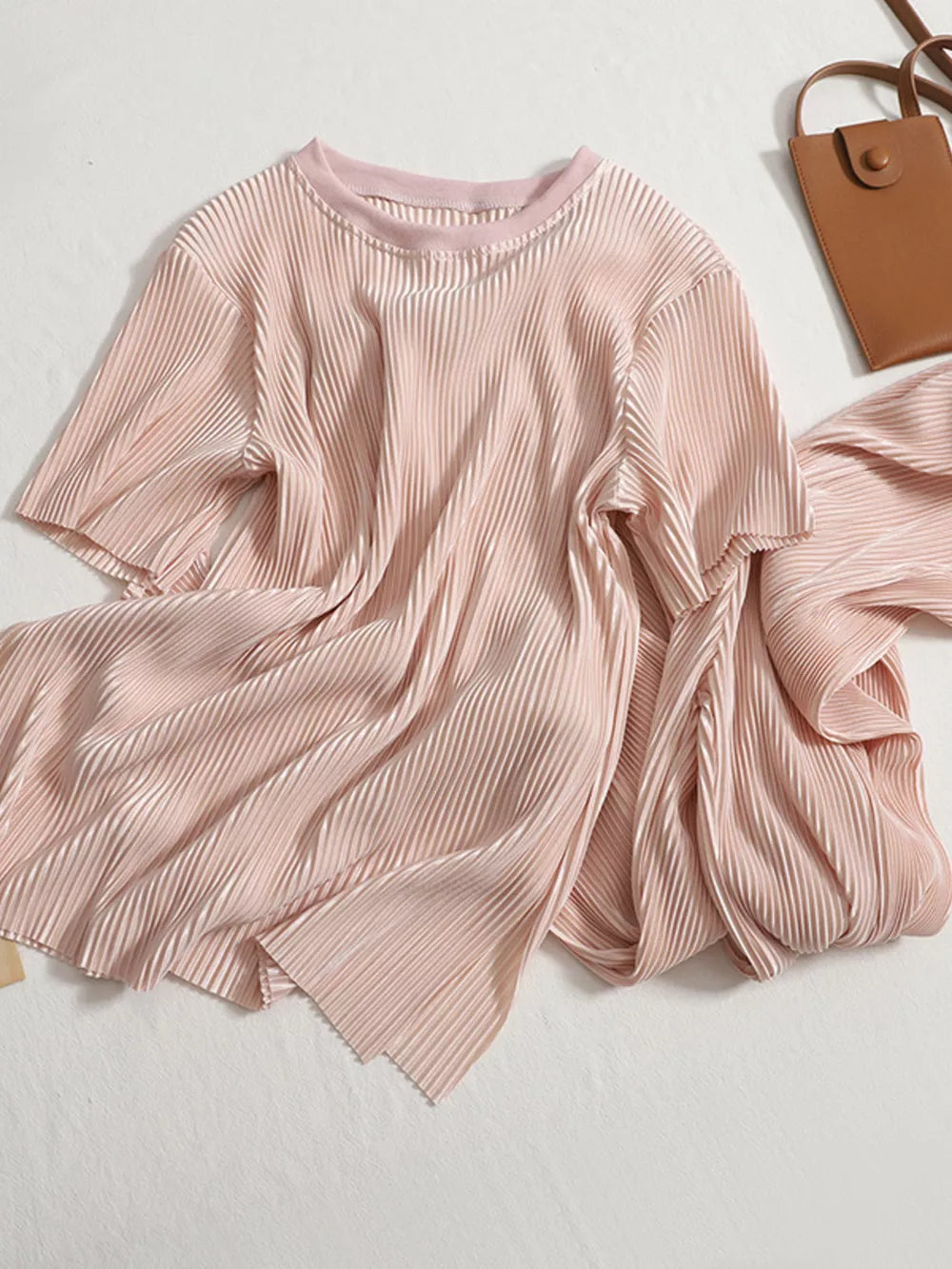 Elegant pink pleated two-piece set with short sleeves and a round neckline.