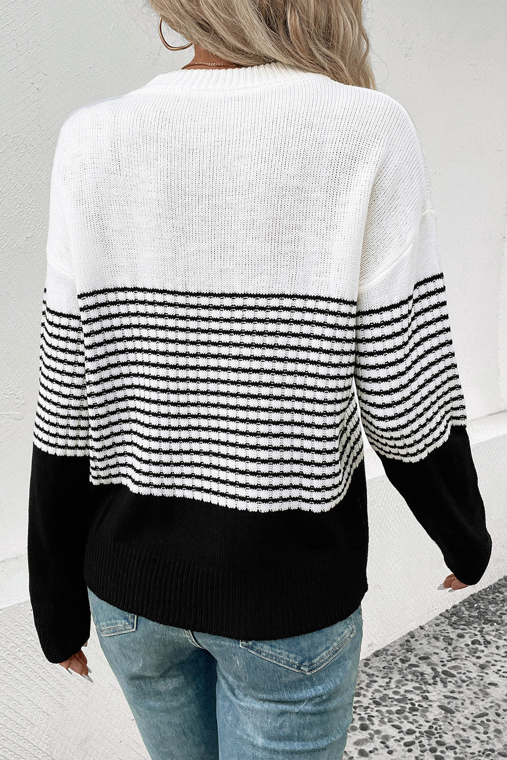 Colorblock stripe crewneck sweater in white and black acrylic with horizontal stripes.