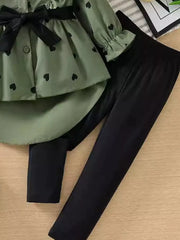 Toddler girls' green heart print peplum top with black bow and ruffle sleeves, paired with black leggings.