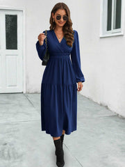 Dark blue tiered midi dress with V-neck, long sleeves, and gathered elastic waist.