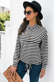 Black and white striped hoodie with button neck and drawstring waist detail.