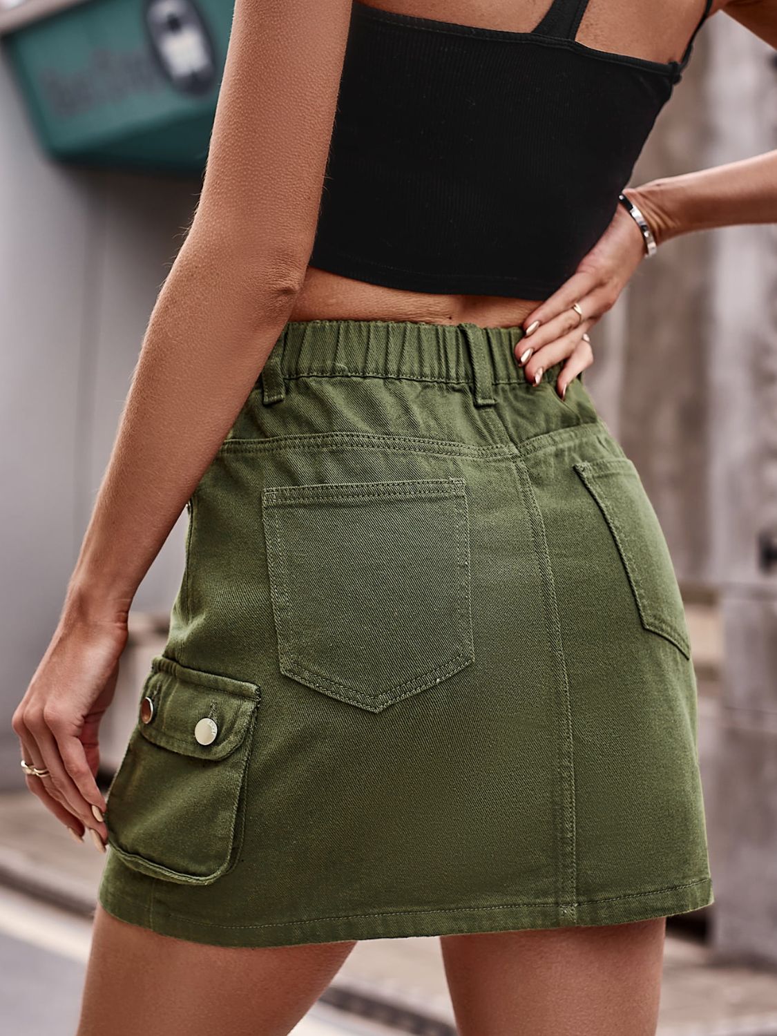 Army green denim mini skirt with cargo pockets and elastic waistband.