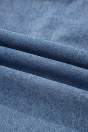 V-shaped pleated denim sleeveless top in blue denim with a textured weave.