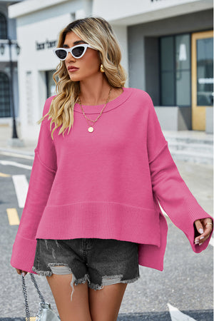 Hot Pink acrylic sweater with flared sleeves and slit hem detail.