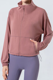 Dusty pink active jacket with gathered hemline, zip front, and pockets.
