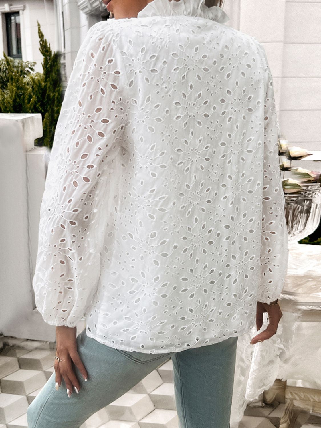 White eyelet embroidered blouse with ruffle collar and balloon sleeves.