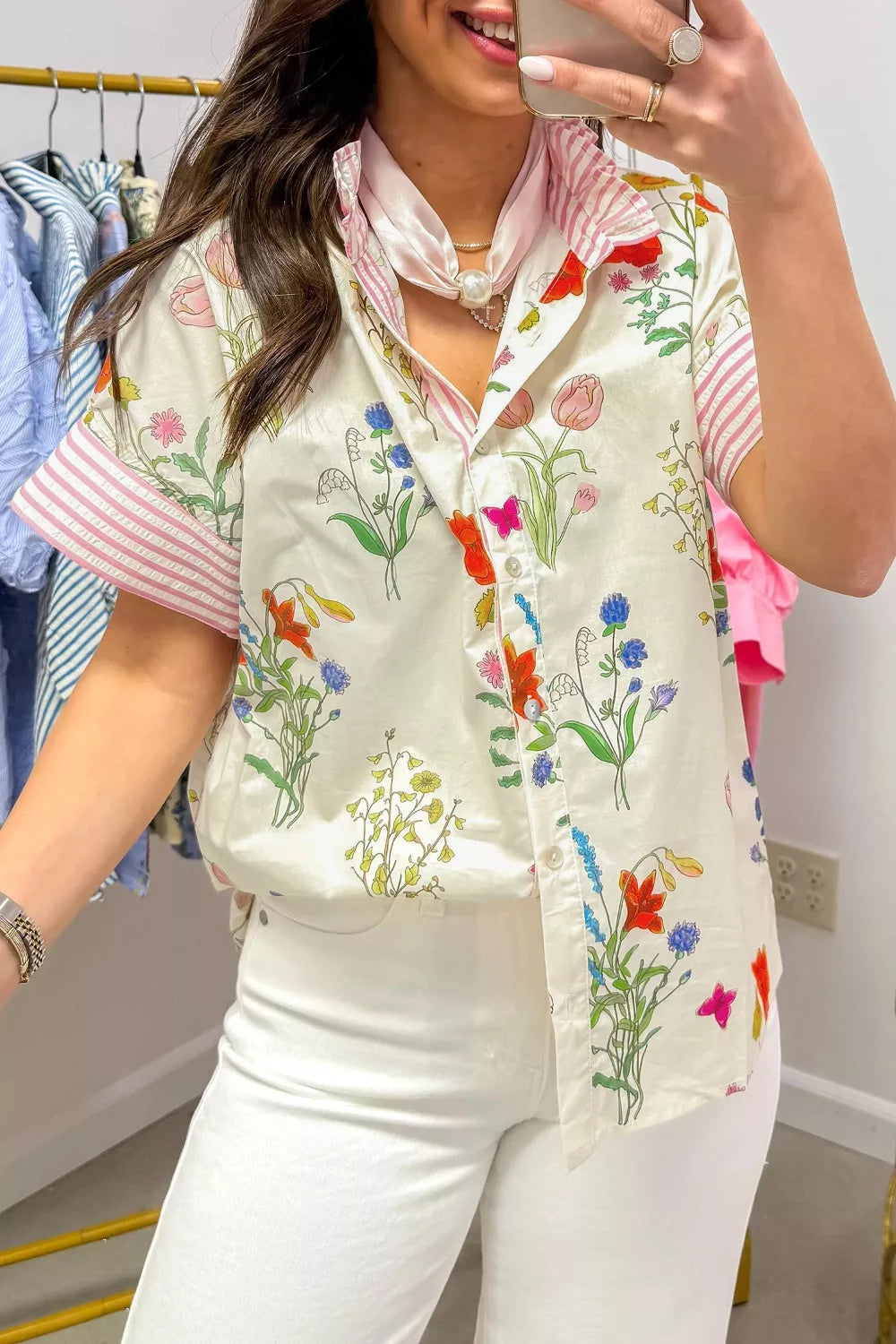 Charming floral print button-down shirt with ruffled collar and pink striped sleeves.
