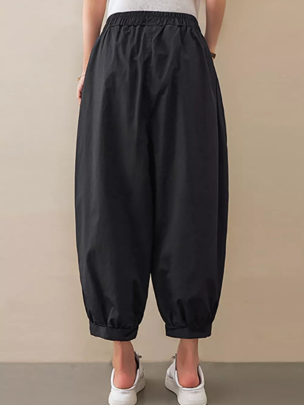 Black relaxed fit harem joggers with elastic waist and cuffed ankles.