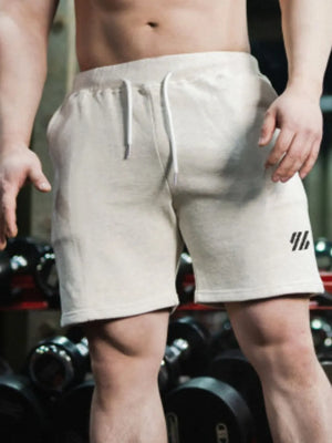 Performance drawstring shorts in light beige with a small black logo detail.
