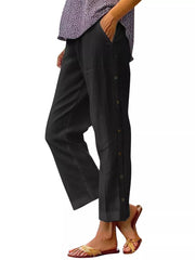 Black relaxed fit pants with decorative side buttons and pockets.