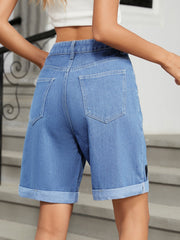 Medium wash denim bermuda shorts with cuffed hems and a heart appliqué detail.