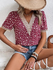 Floral lace trim v-neck blouse in maroon with a white floral print and short sleeves.