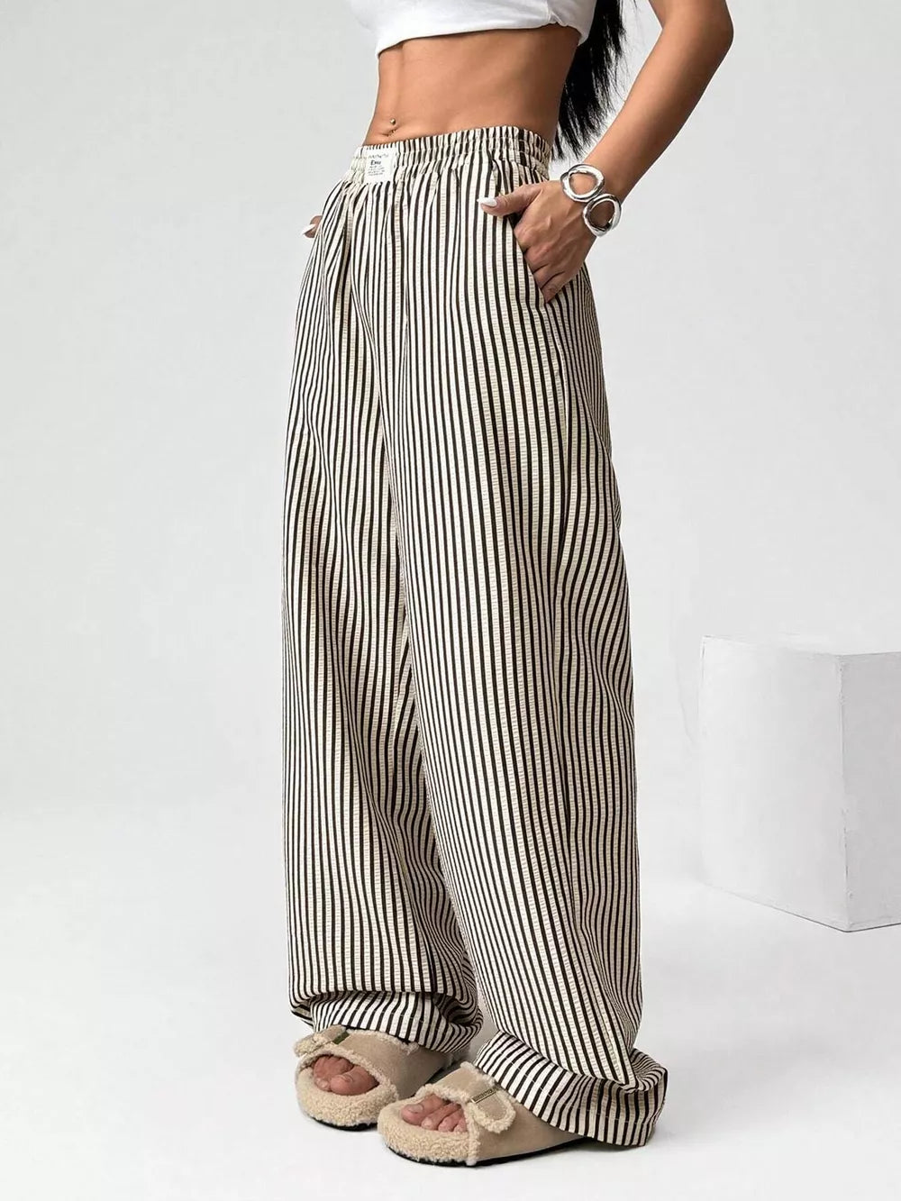 Navy striped high-waisted wide-leg pants with drawstring detail and pockets.