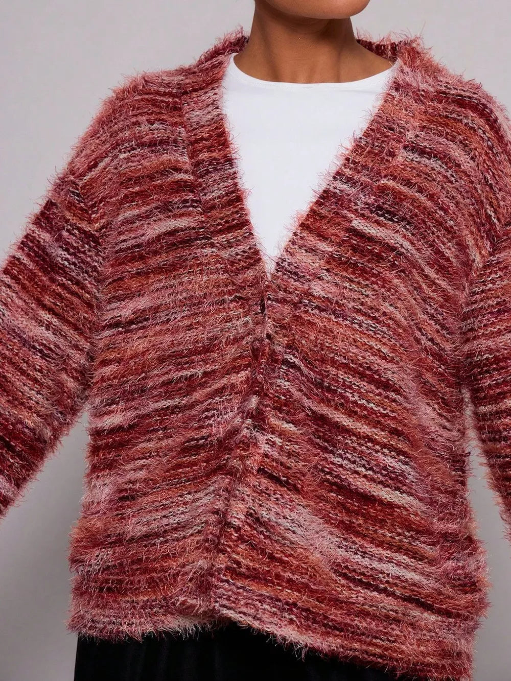 Cozy textured knit cardigan in a marled rust and pink blend with a V-neck and button front.