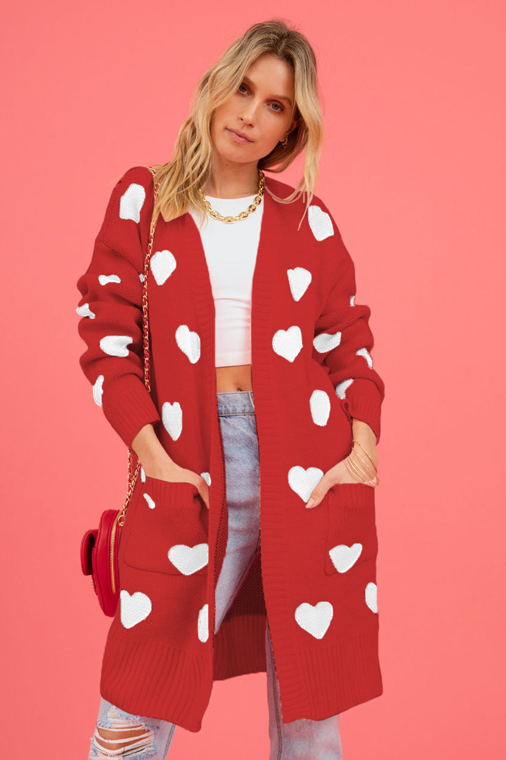 Red longline knit cardigan with white heart pattern, open front, pockets, acrylic.