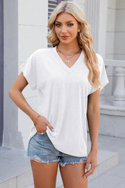 White dolman sleeve slouchy v-neck top with rolled cuffs and a relaxed fit.