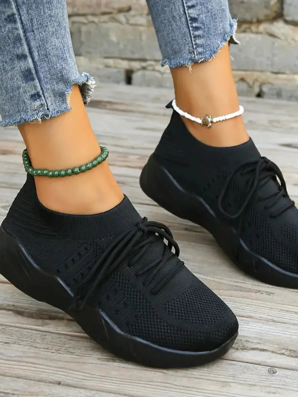 Black knit runner sneakers with sculpted sole and lace-up closure.