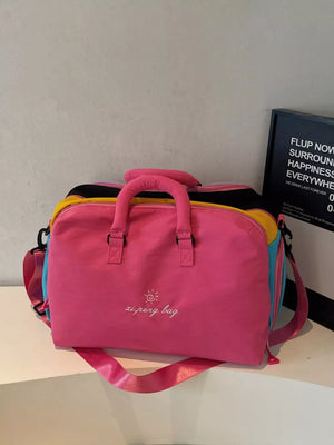 Vibrant pink duffel bag with embroidered text and multi-color panels.