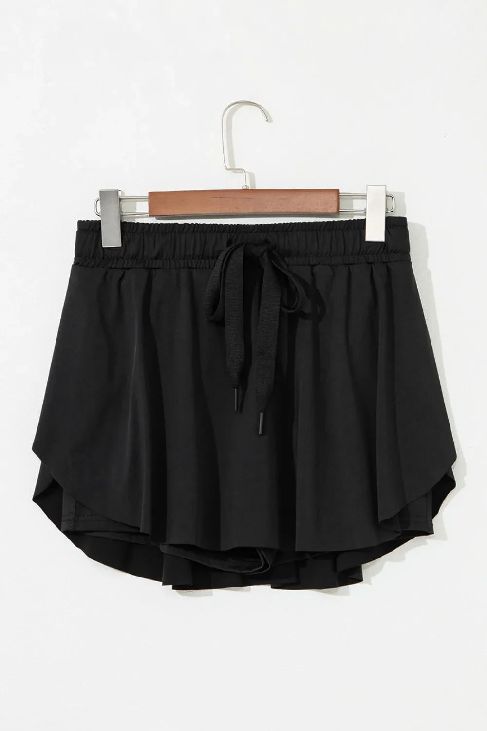Black flared skort with tie waist and elastic waistband.