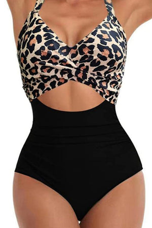 Leopard print halter one-piece swimsuit with crisscross cutout and black high-waisted bottom.