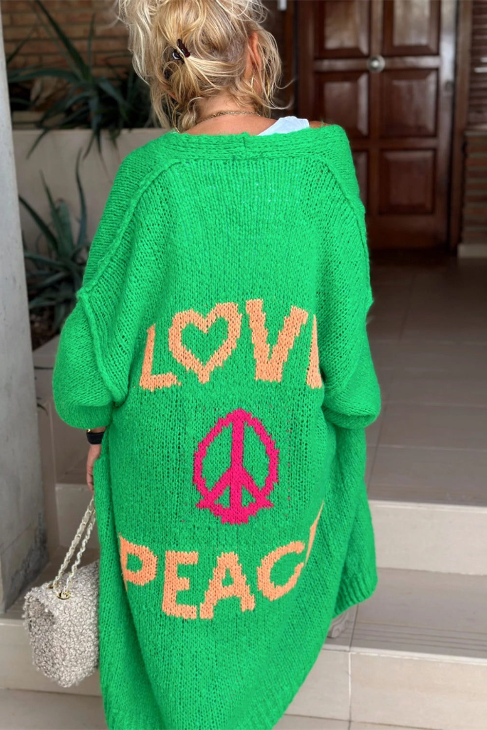 Green maxi knit cardigan with orange LOVE and PEACE sign graphic, long sleeves, relaxed fit