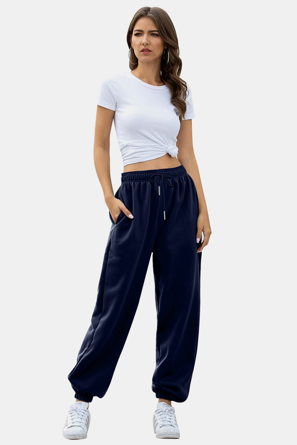 Navy sweatpants with gathered cuffs and drawstring waist, styled with a white crop top.