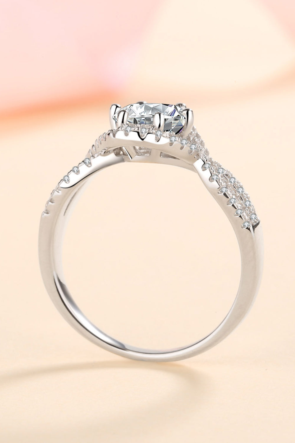 Silver moissanite engagement ring with halo and pave band.