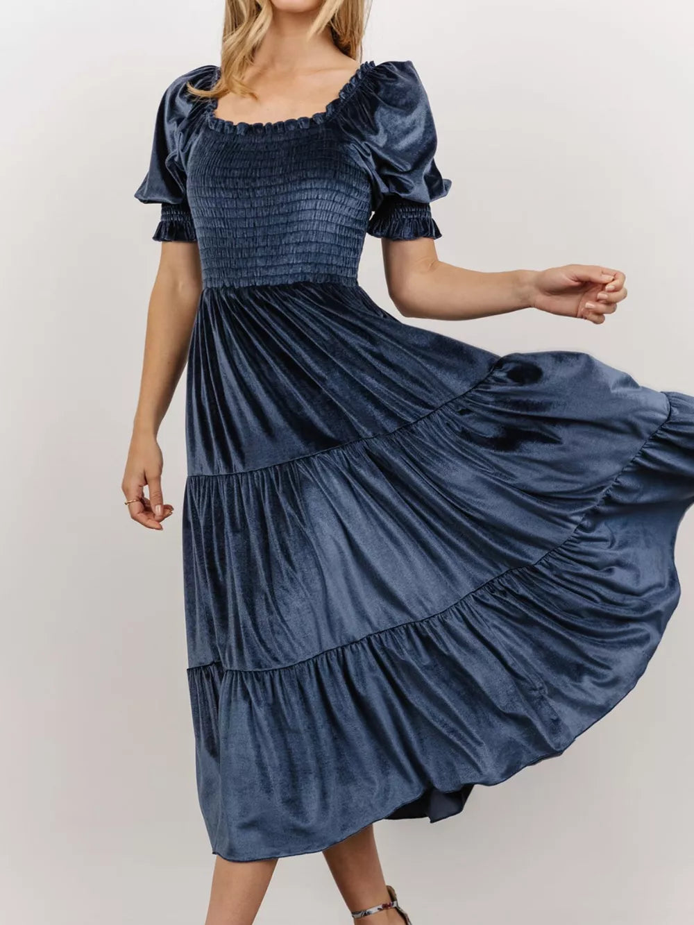 Dusty blue velvet midi dress with smocked bodice and ruffled puff sleeves.
