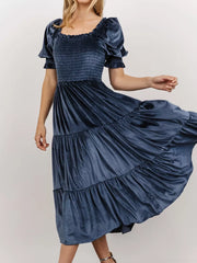 Dusty blue velvet midi dress with smocked bodice and ruffled puff sleeves.