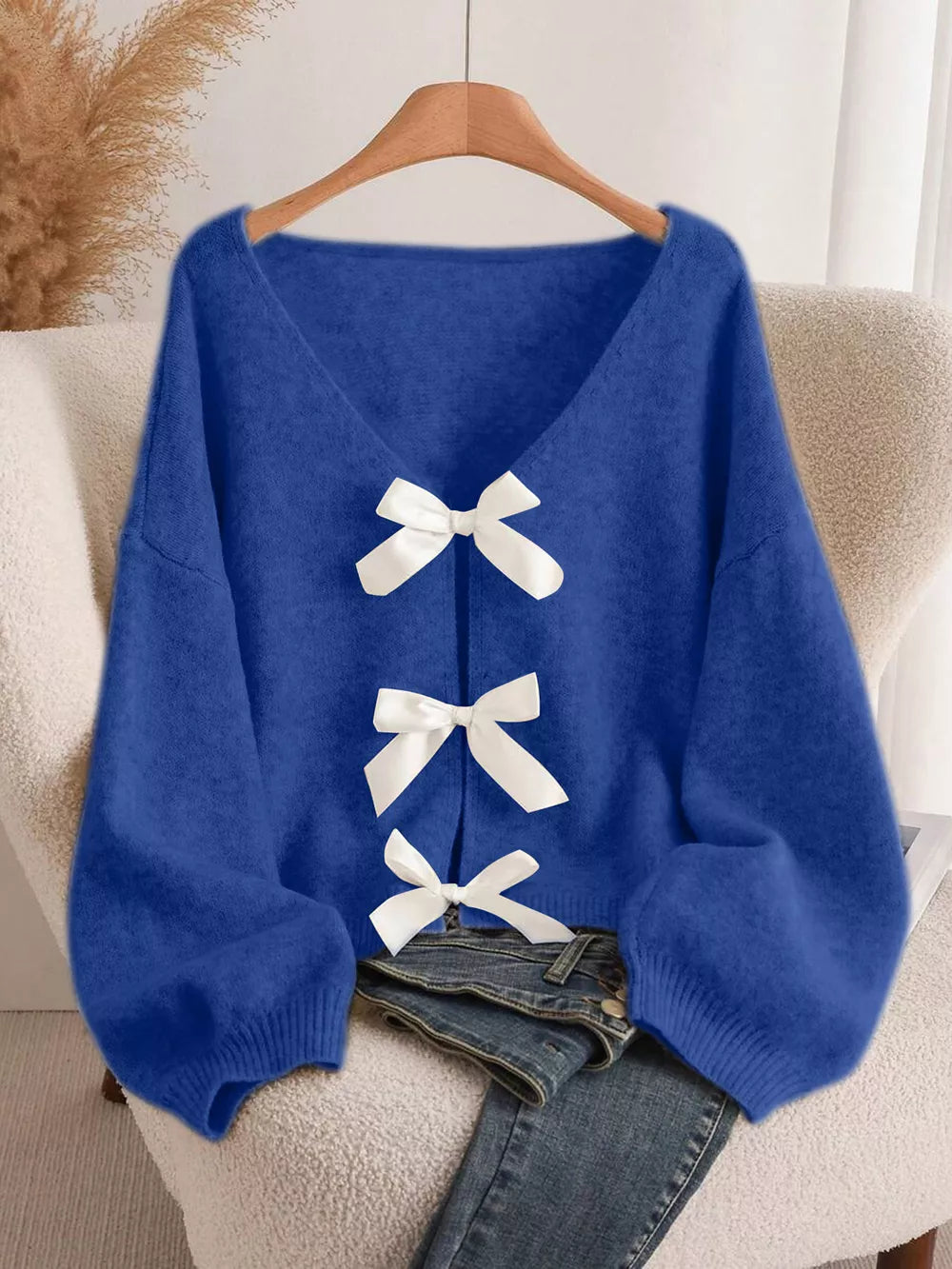Blue V-neck cardigan with balloon sleeves and white bow-knot details.