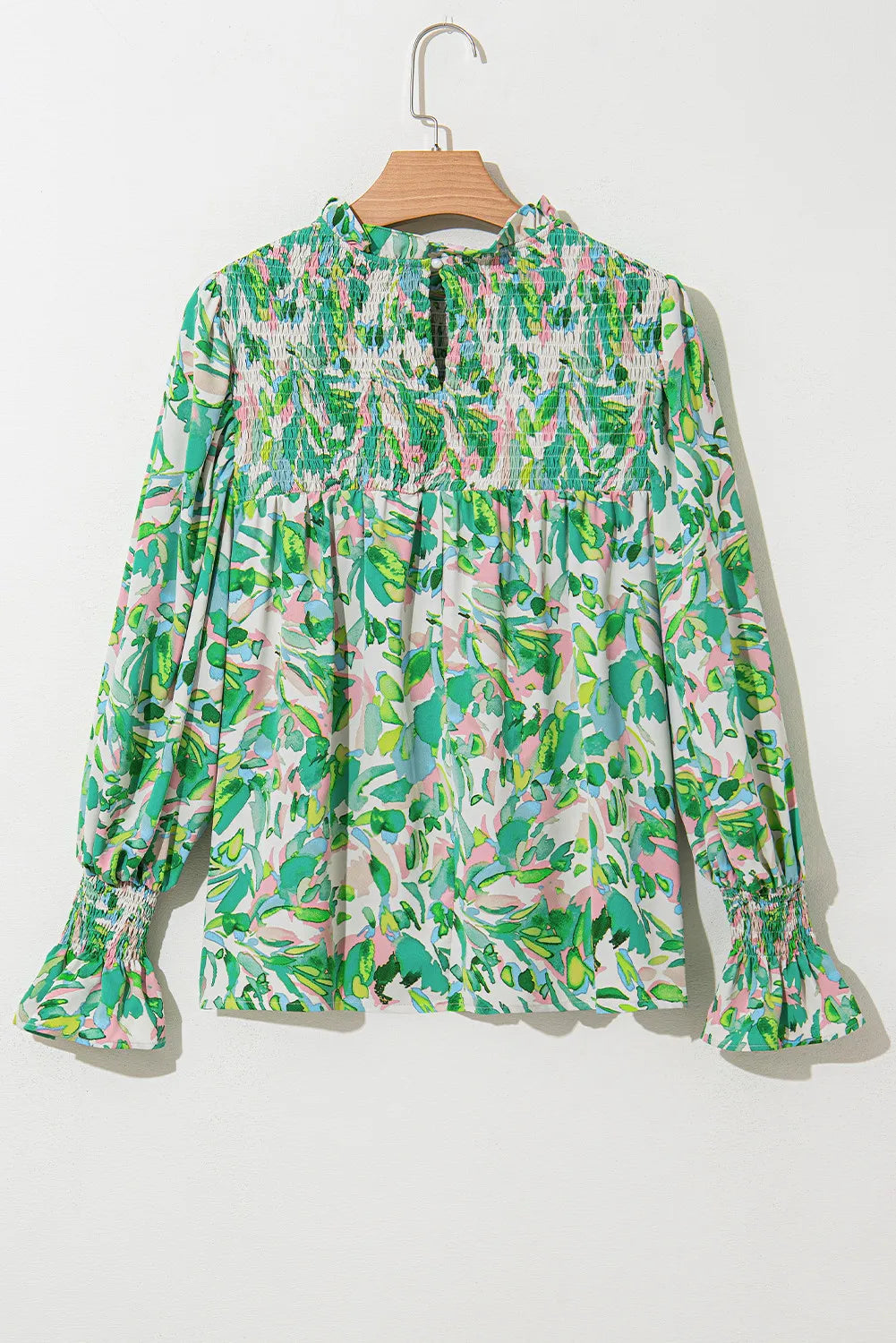 Green abstract floral print blouse with smocked yoke and voluminous sleeves.