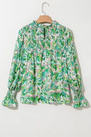 Green abstract floral print blouse with smocked yoke and voluminous sleeves.