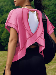 Pink t-shirt with exposed seams and cutout back detail, worn over a white tank top.