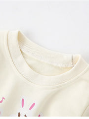 Ivory crew neck sweatshirt with cute rabbit piano graphic, 100% cotton.